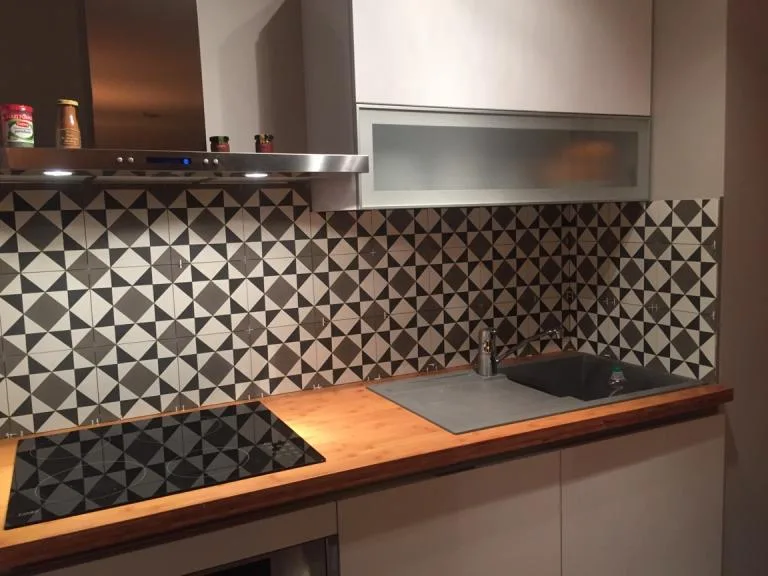 Crédence de carreaux de ciment à motifs géométriques dans une cuisine.