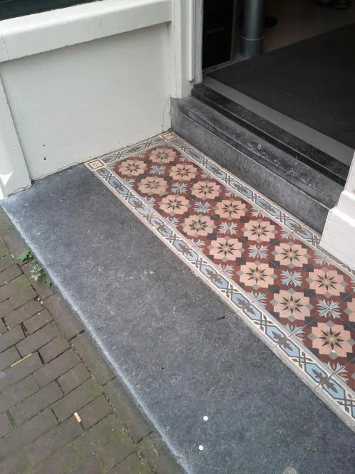 Carreaux de ciment anciens dans une entrée de maison à Amsterdam