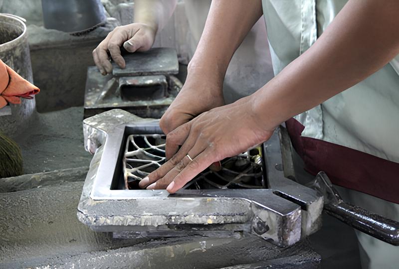 Un artisan place le diviseur représentant le motif du carreau de ciment à fabriquer